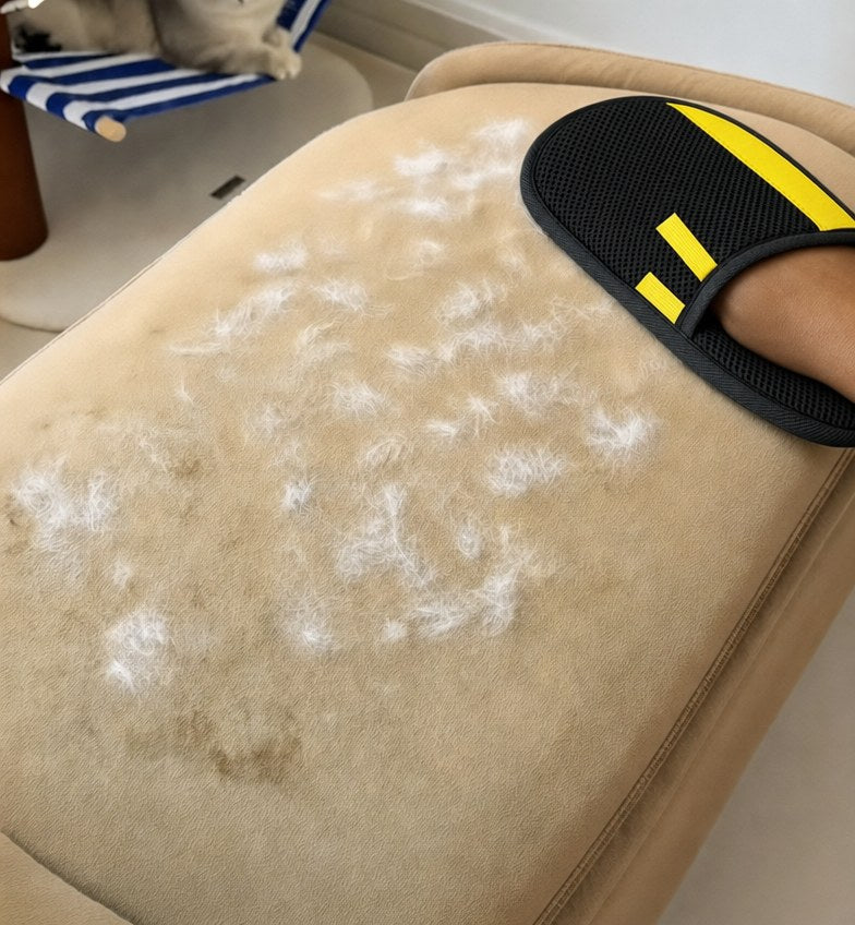 Rearpaw glove lifting white pet hair from a beige couch