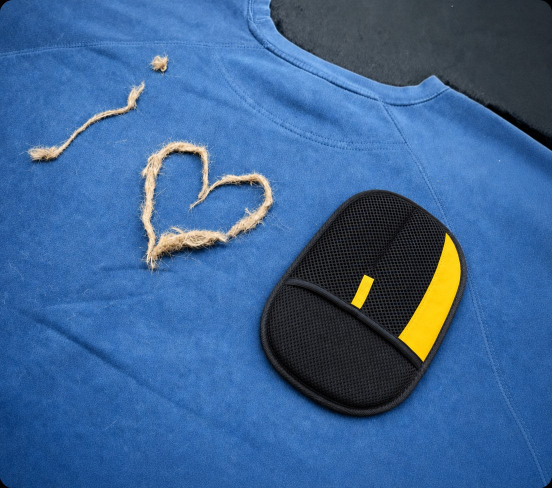 Rearpaw glove next to pet hair shaped as a heart on a blue shirt